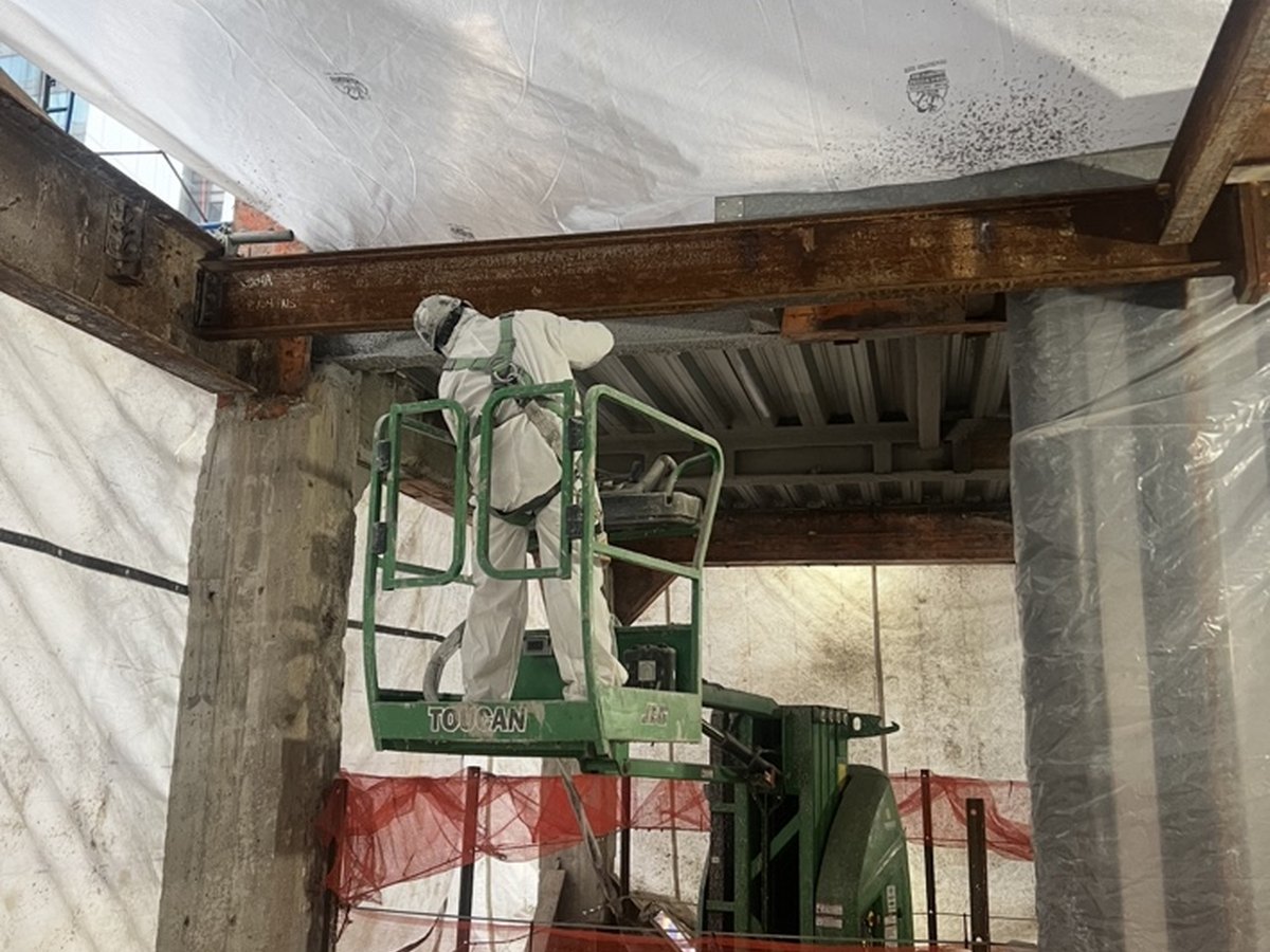PAL worker applying fireproofing from a lift